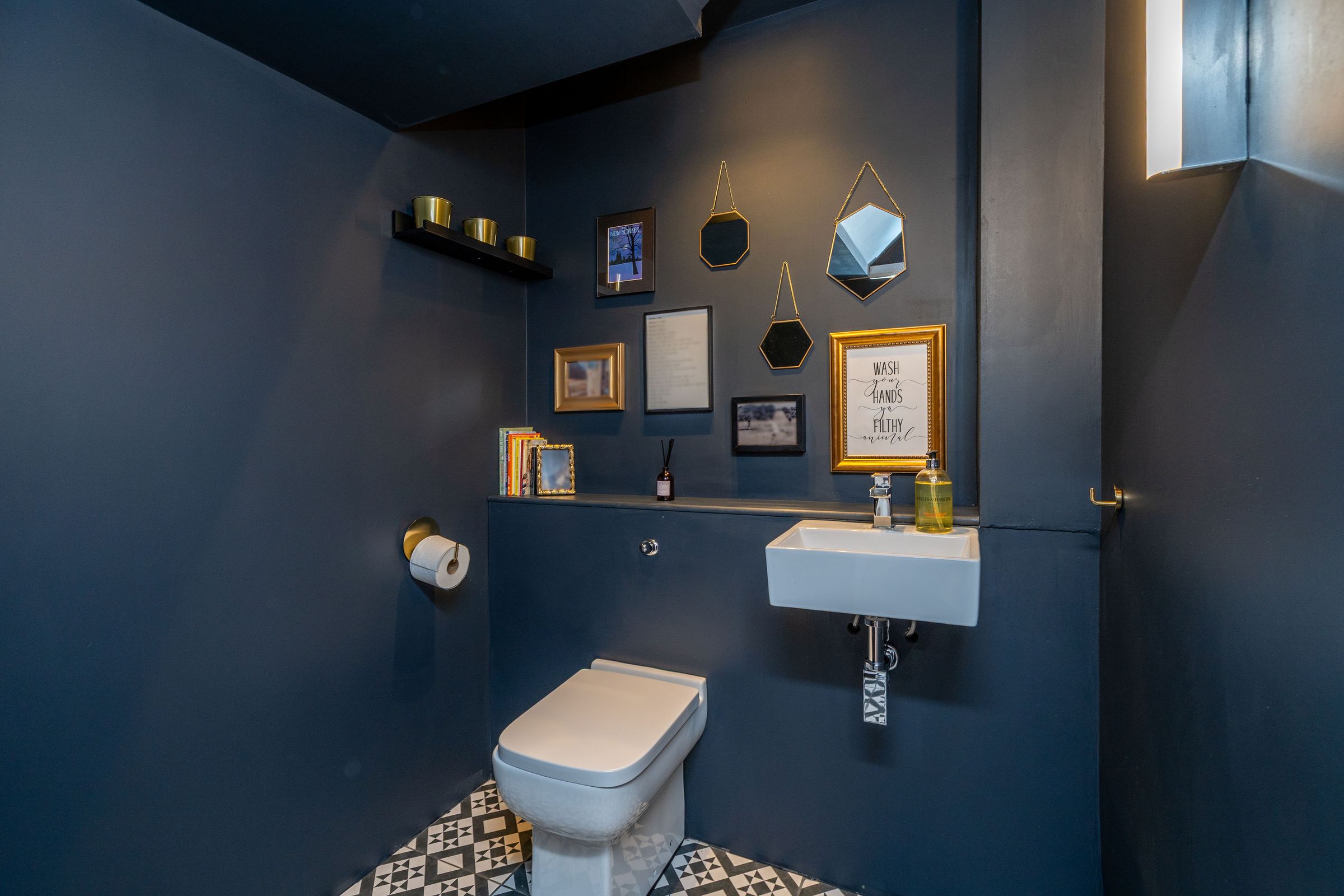 Cloakroom painted in deep navy with gold accents — Edinburgh