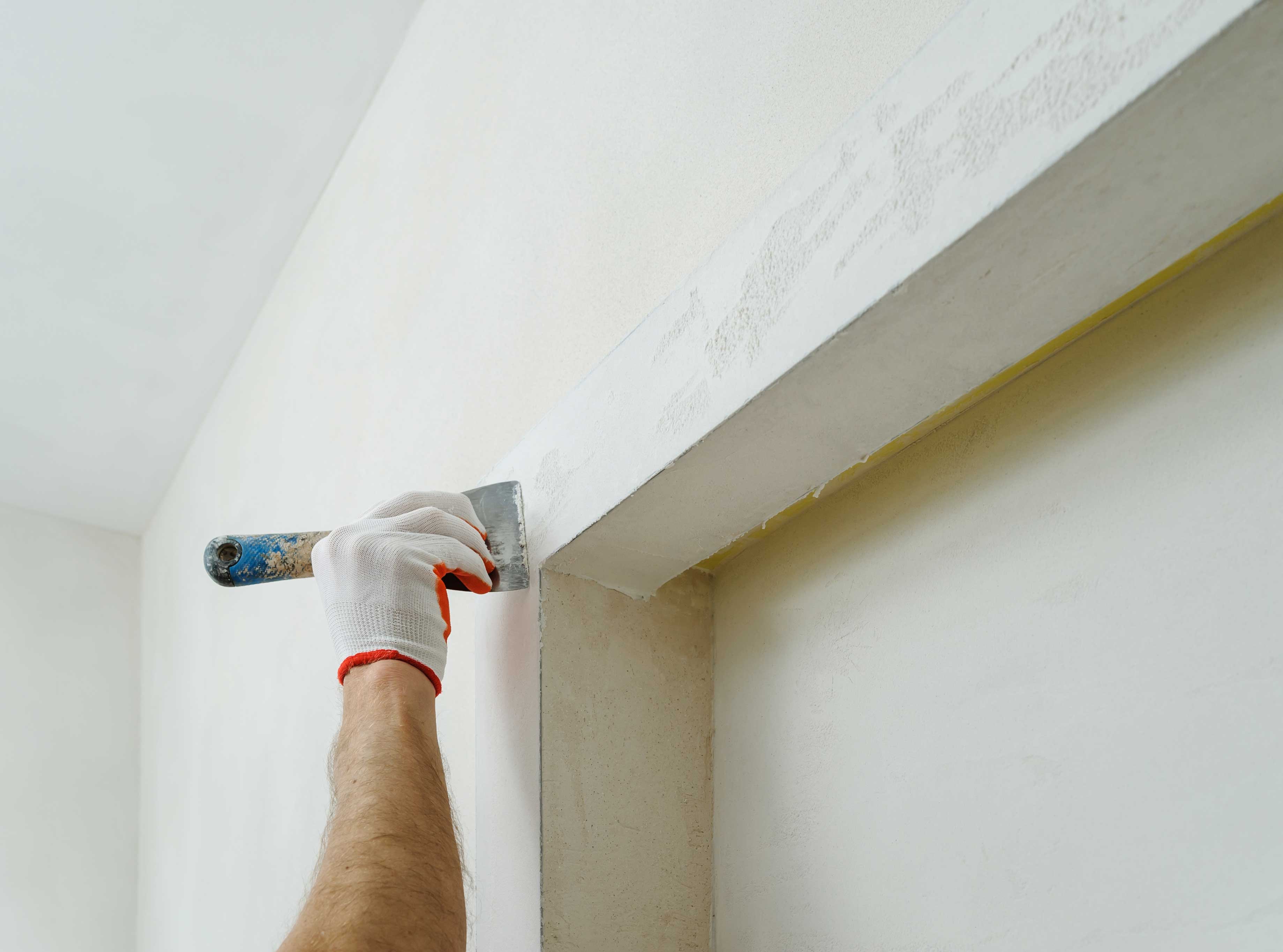 Plasterer smoothing a fresh skim coat along a crisp corner reveal — Stockbridge, Edinburgh