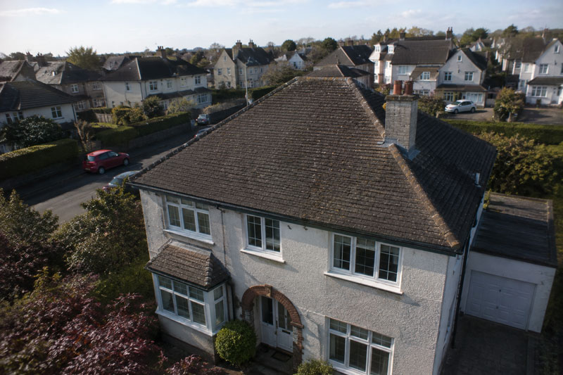 Full aerial drone photo of a house roof, showing the whole property and roof condition from above
